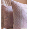 Two dusty pink embroidered cushion cover pillows with white floral and geometric stitching. hand done skilled chikankari made in india,styled on a sofa.