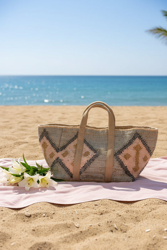 A woven tote bag with a geometric pattern in beige, pink, and gray, featuring two top handles.