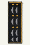 A long, narrow navy blue hand woven rug with a yellow border, white curved geometric motifs, and small yellow circular accents.