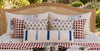 a striped and patterned hand block printed bedding set in red, white, and blue, decorative throw pillows and cushion covers